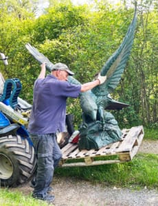Slowly does it Carefully moving the statue with a digger