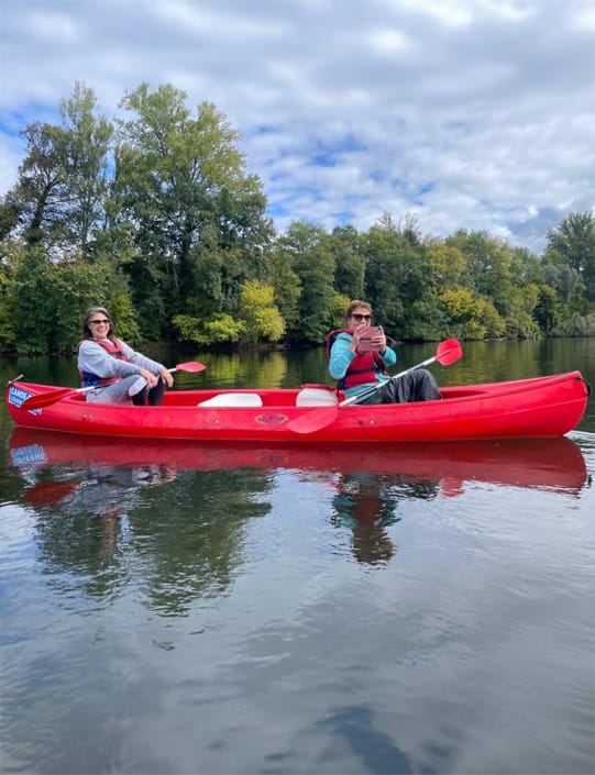 Having fun on the river Two friends having fun in a canoe on the River Dordogne